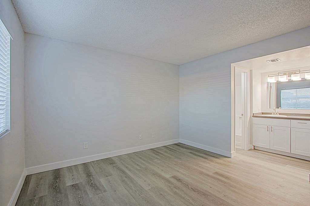 an empty bedroom with white walls and a bathroom