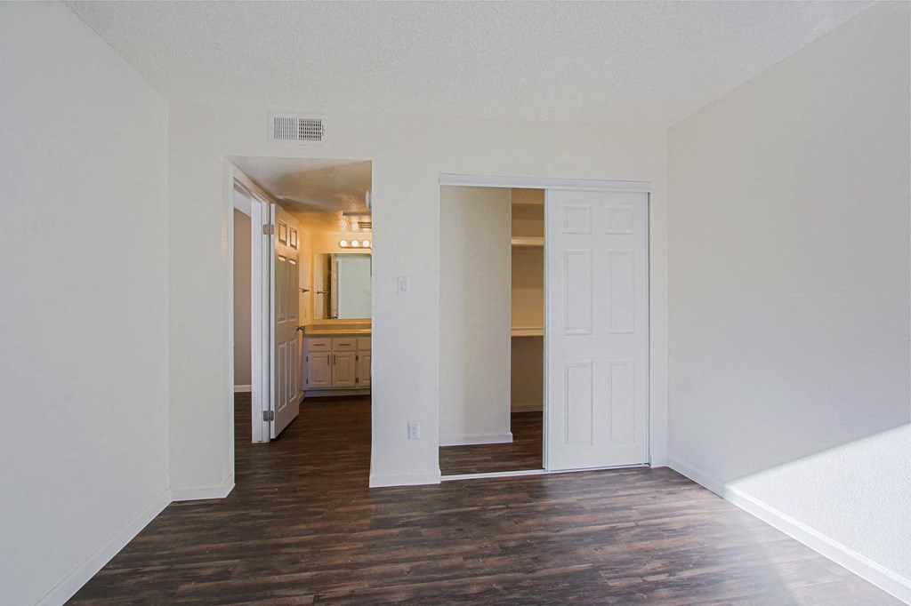 an empty living room with white walls and a wood floor