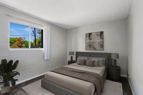 Bedroom with white brick wall and gray bedding at The Link Apartments, Mesa, AZ 85201