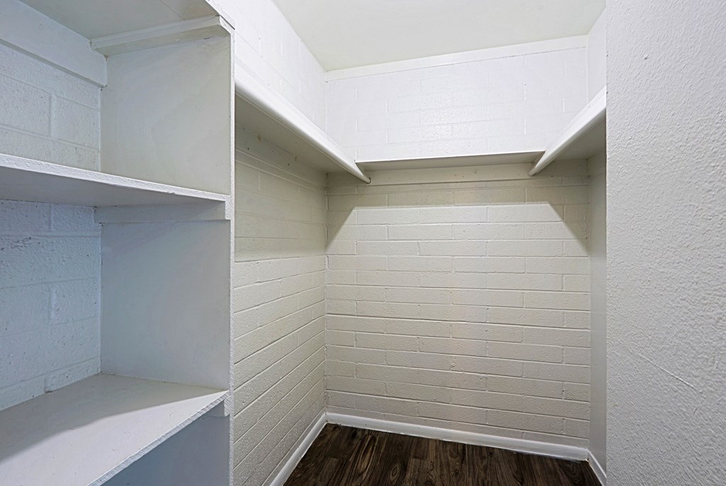 A white brick wall with a wooden floor.