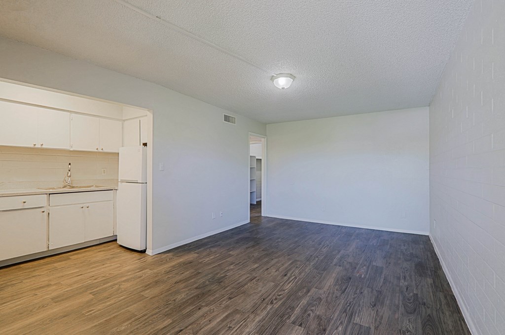 A room with a white wall and wooden floor.