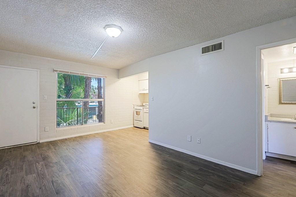 A spacious room with a window, a sink, and a washer and dryer.