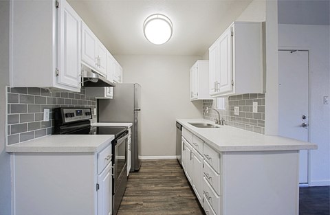 an empty kitchen with white cabinets and stainless steel appliances