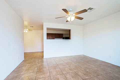 Empty room with a ceiling fan and tiled floor.
