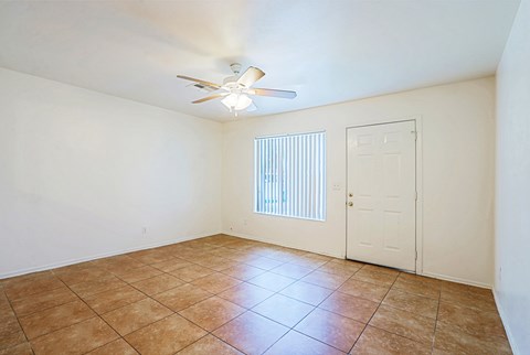 A room with a ceiling fan and a door.