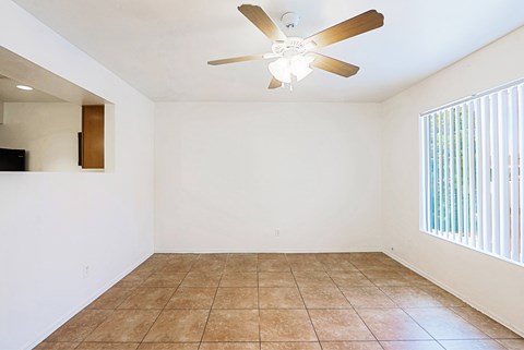 A room with a ceiling fan and tiled floor.
