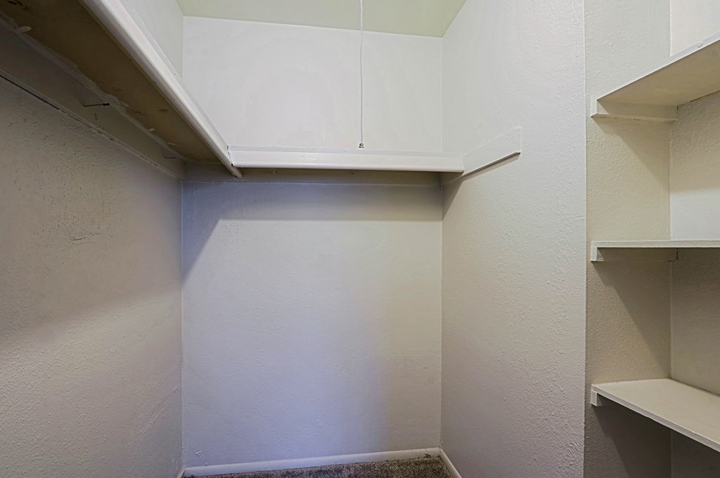 A white kitchen with a cabinet and a shelf.