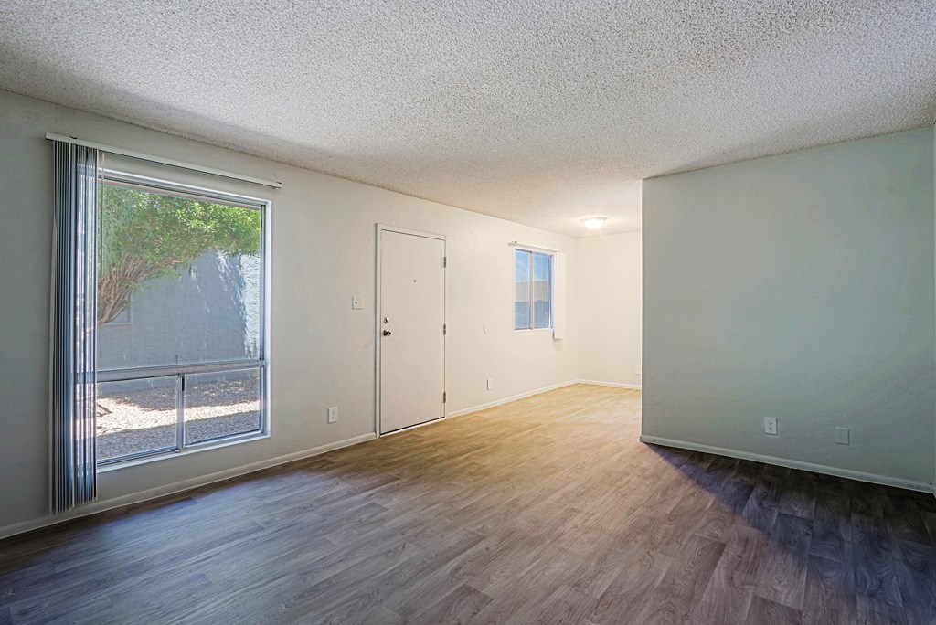A room with a sliding glass door and a wooden floor.