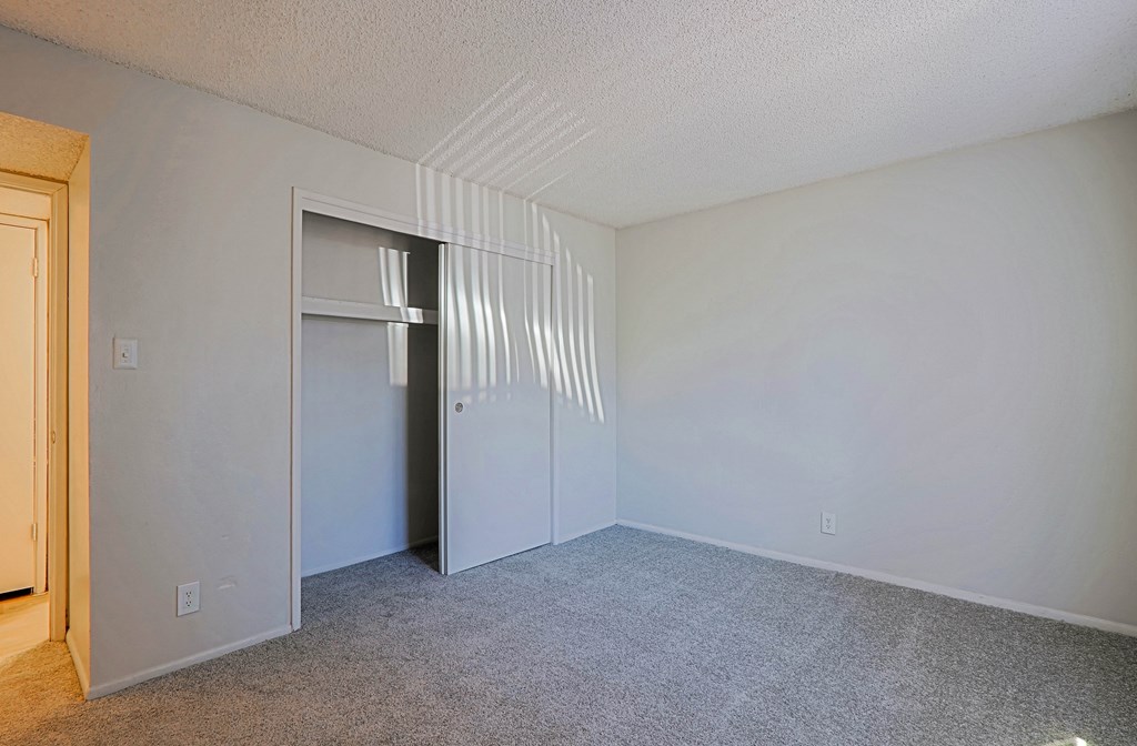 A room with a carpeted floor and a door.