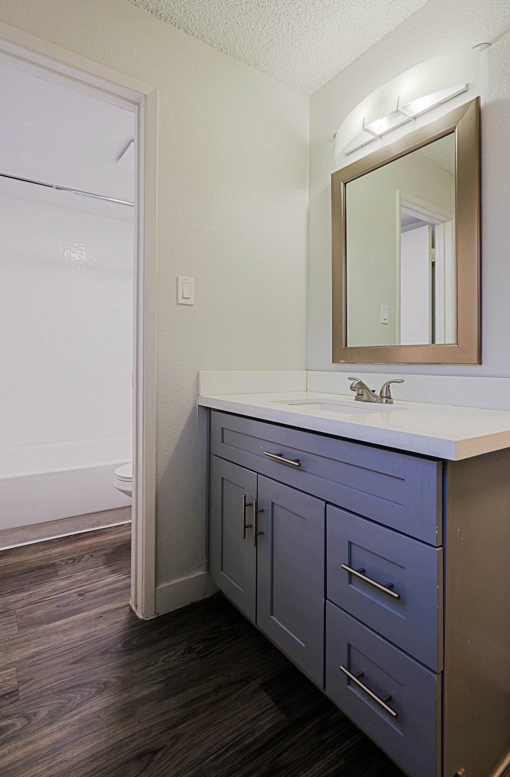 A bathroom with a white sink and a mirror above it.