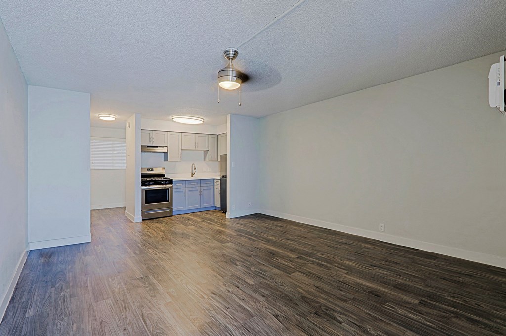 A kitchen with white cabinets and a stove top oven.