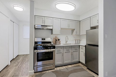 A kitchen with a stove top oven and a refrigerator.
