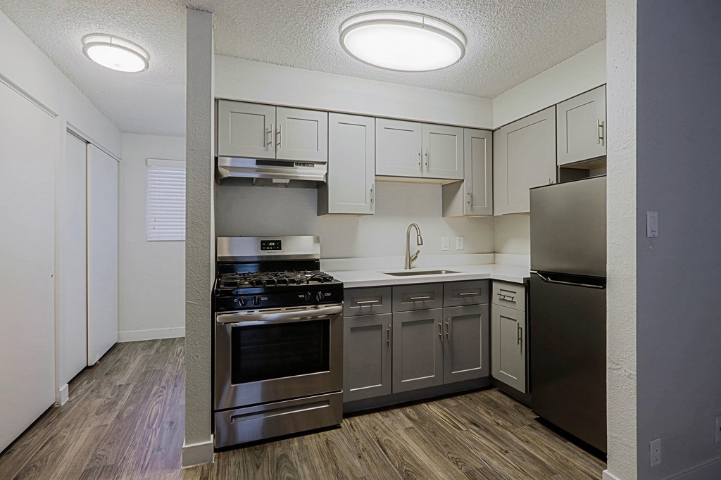 A kitchen with a stove top oven and a refrigerator.