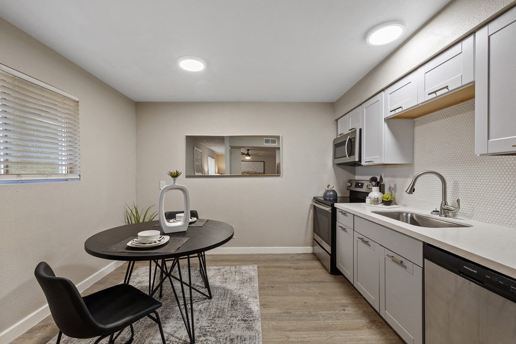 A kitchen with a table and a chair.