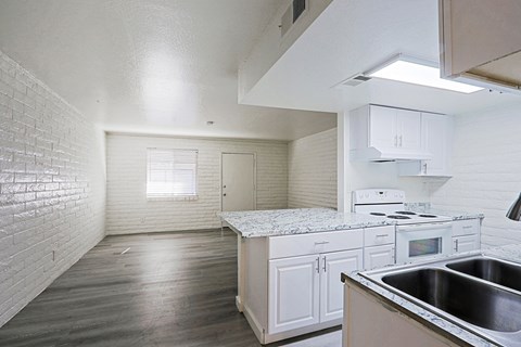 A kitchen with white cabinets and a stove top oven.