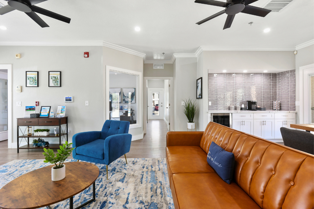 A living room with a brown leather couch and a blue armchair.
