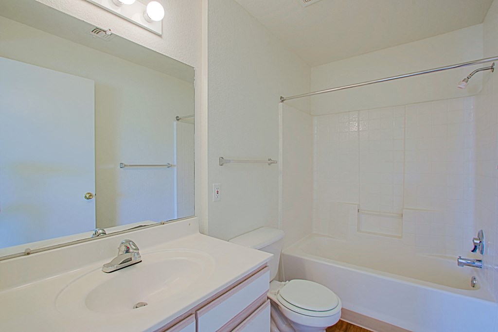 A white bathroom with a sink, toilet, and bathtub.