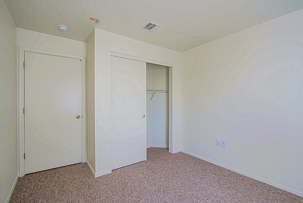 A room with two doors and a carpeted floor.