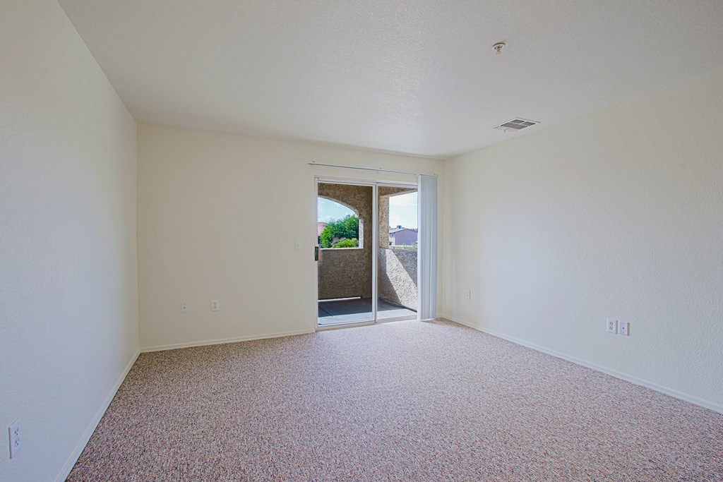 A room with a carpeted floor and a doorway leading to another room.