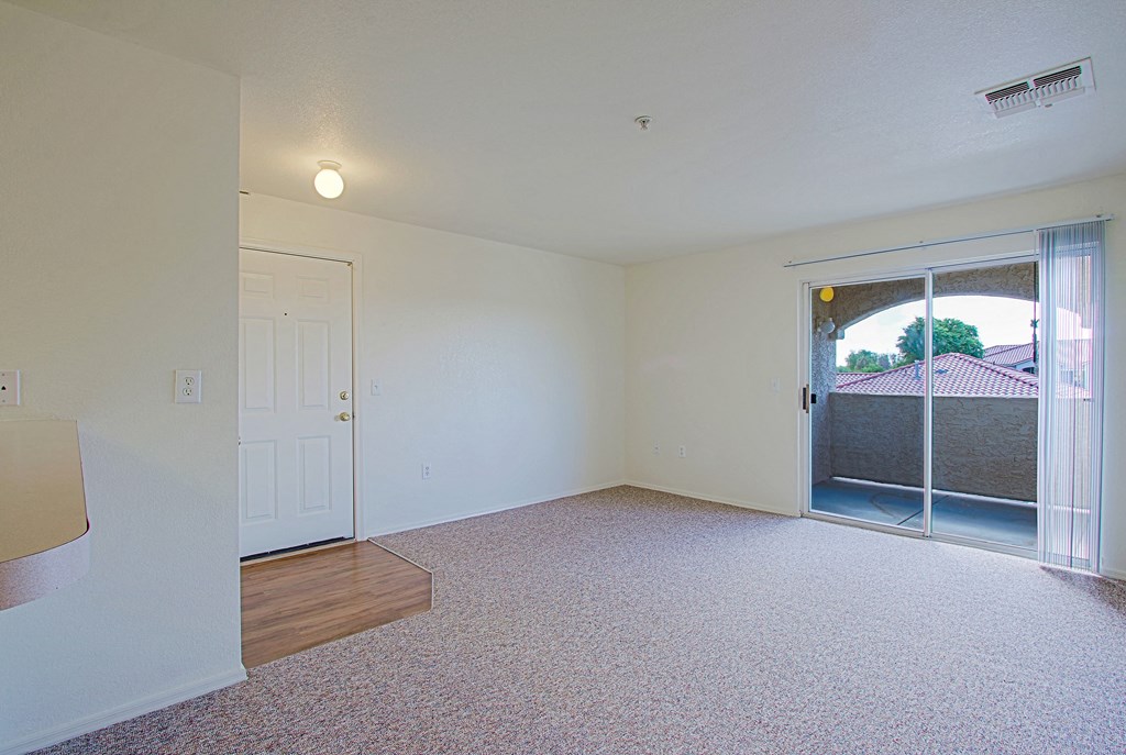 A room with a sliding glass door leading to a backyard.