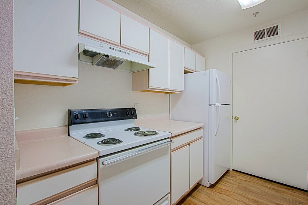 A kitchen with a stove and a refrigerator.