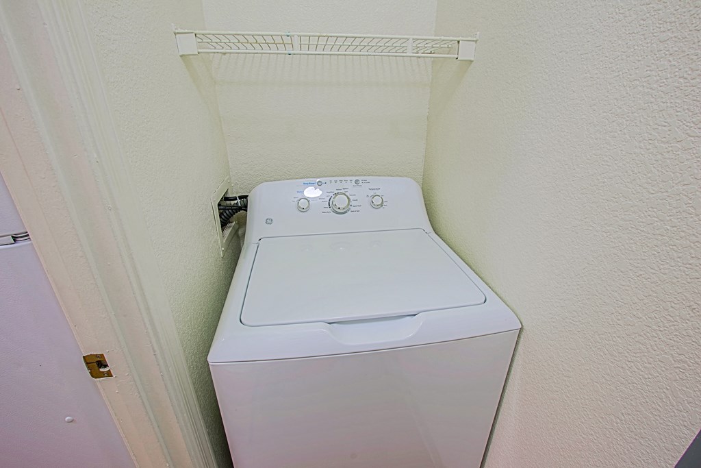 A white washing machine in a small room.
