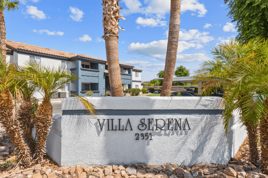 a wall with the villa sierra name on it and palm trees in front of it