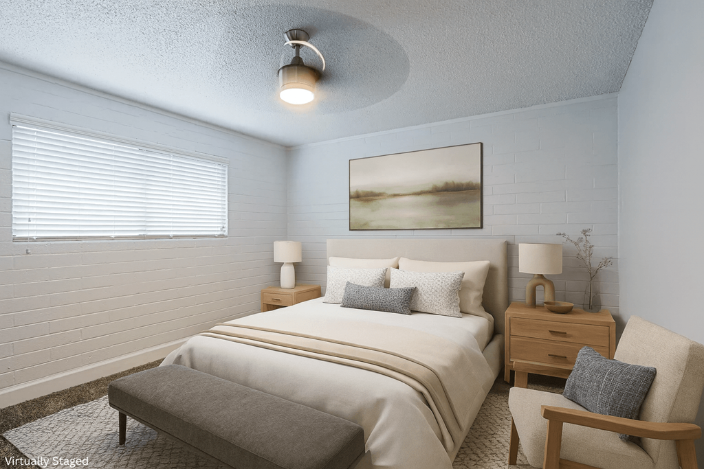 A bedroom with a bed, nightstand, and chair.