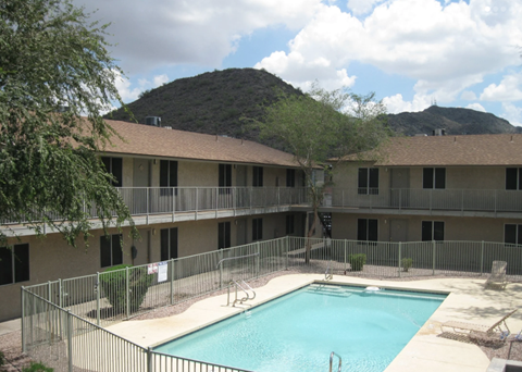 A pool surrounded by a fence in a courtyard.