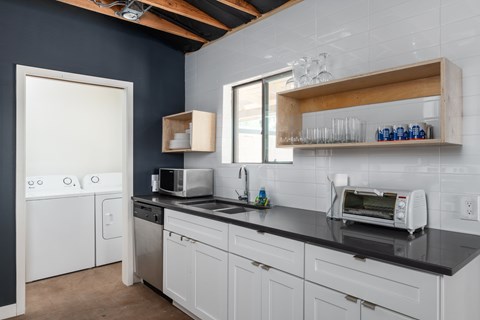 A kitchen with white appliances and wooden shelves.