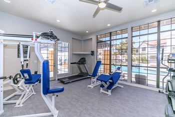 Fitness Center with various machines and weights with view of soothing swimming pool at Tides at Mesa, Mesa, Arizona