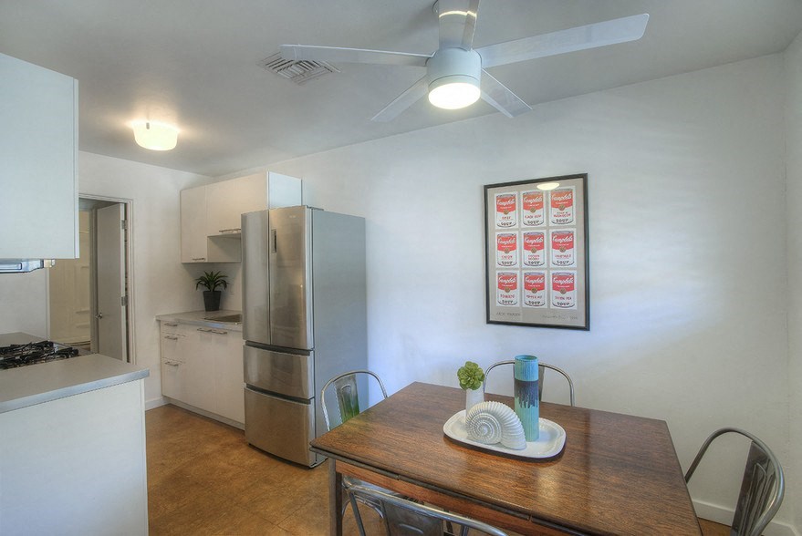 a kitchen with a wooden table and a stainless steel refrigerator