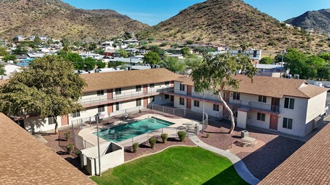 A large house with a pool in the middle of a grassy area.