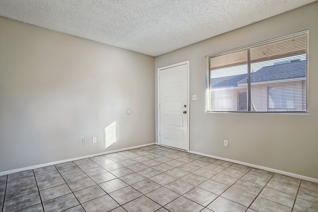 A room with a white door and a window with blinds.