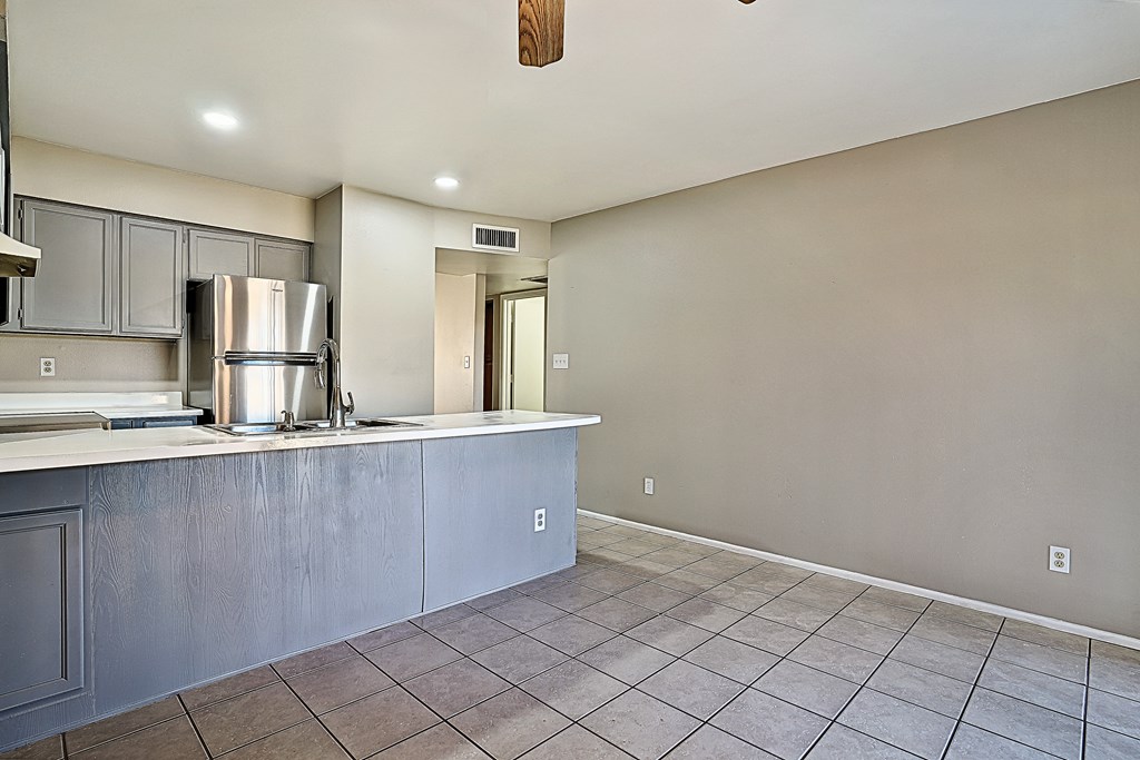 A kitchen with a refrigerator, stove, and sink.