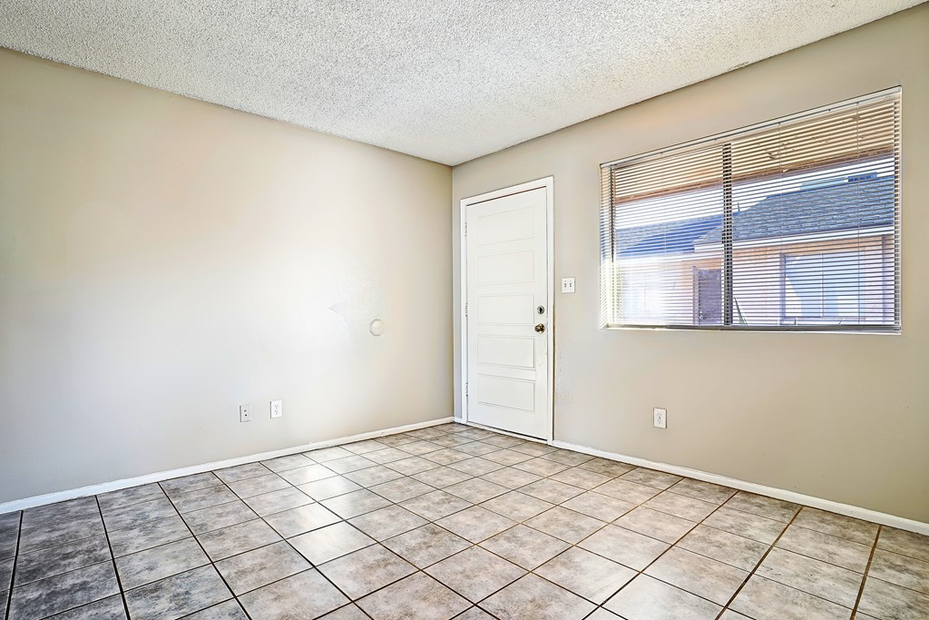 A room with a tiled floor and a window with blinds.