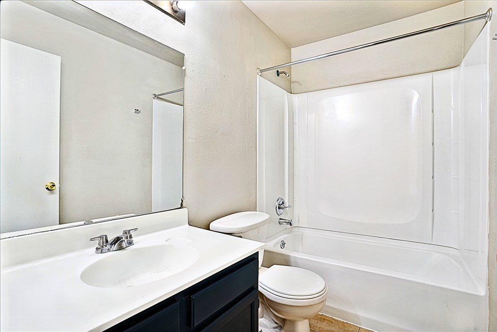 A white bathroom with a sink, toilet, and bathtub.