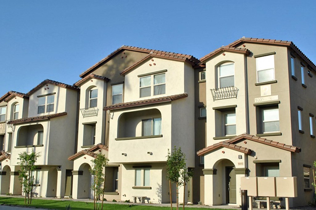 a row of town houses with trees in front of them