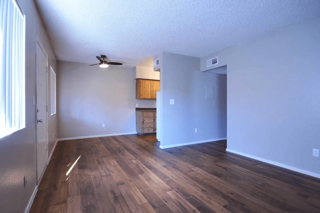 A room with wooden floors and a ceiling fan at Gilbert Square Apartments, Mesa