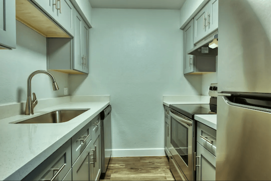 A kitchen with a sink, stove, and oven at Gilbert Square Apartments, Arizona