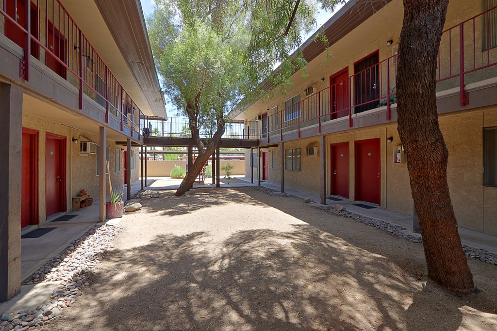 a courtyard with trees and red doors