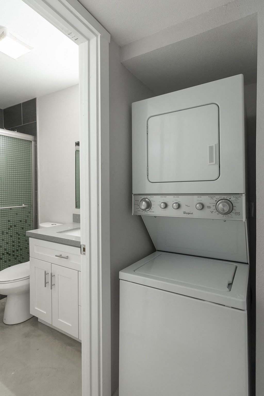 a washer and dryer in a grey and white bathroom