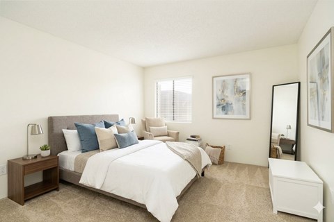 A bedroom with a large bed and a nightstand with a lamp.