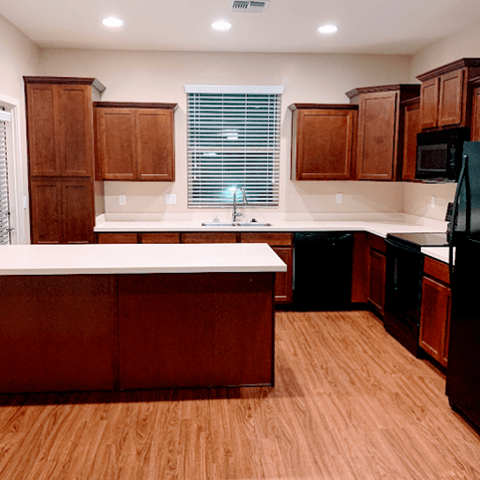 a large kitchen with wooden floors and wooden cabinets
