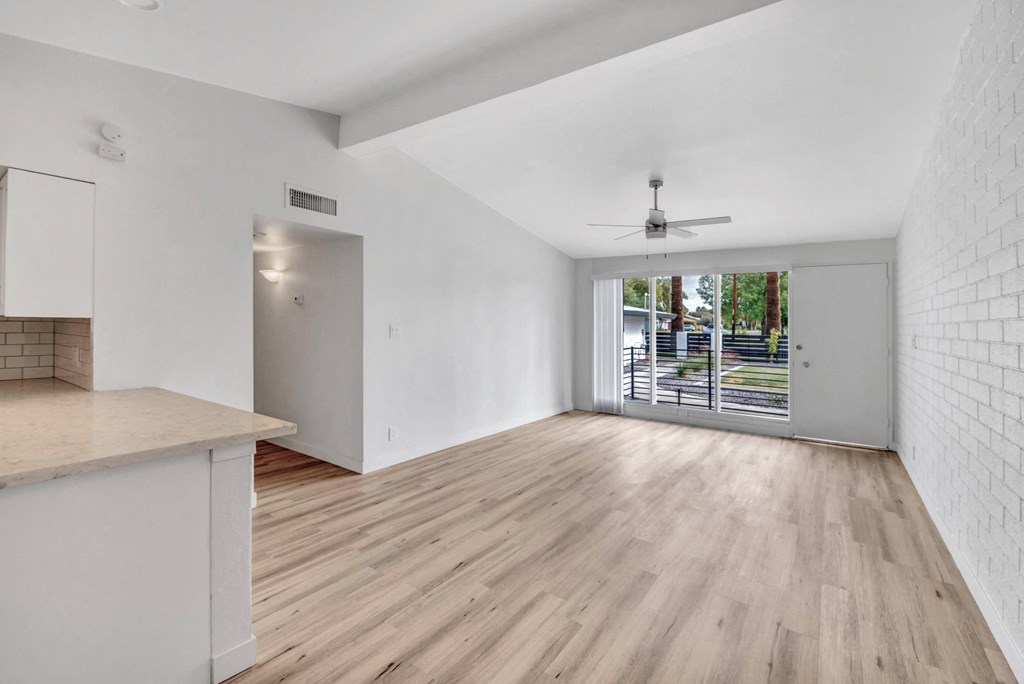 a living room with white walls and a sliding glass door to a patio