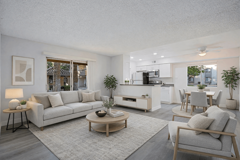 A modern living room with a grey sofa, wooden coffee table, and a grey armchair.