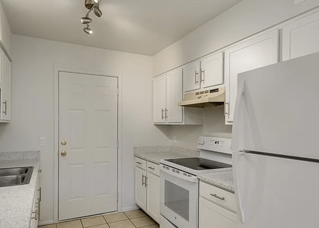 a white kitchen with white appliances and white cabinets