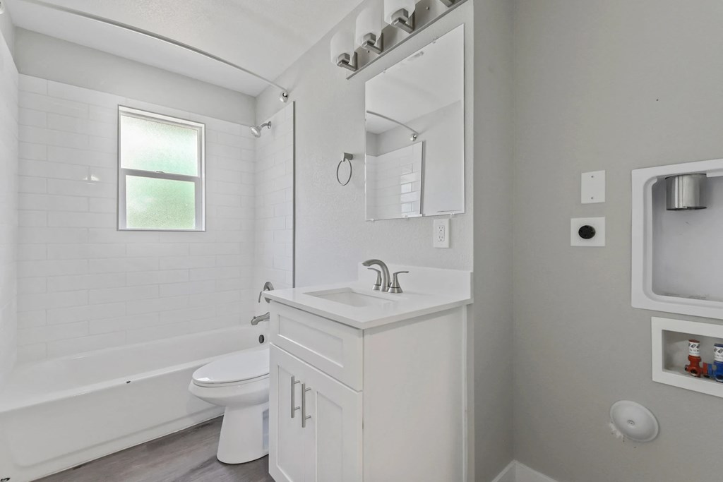 A white bathroom with a tub, toilet, and sink.