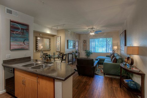 a kitchen and living room with a sink and a ceiling fan