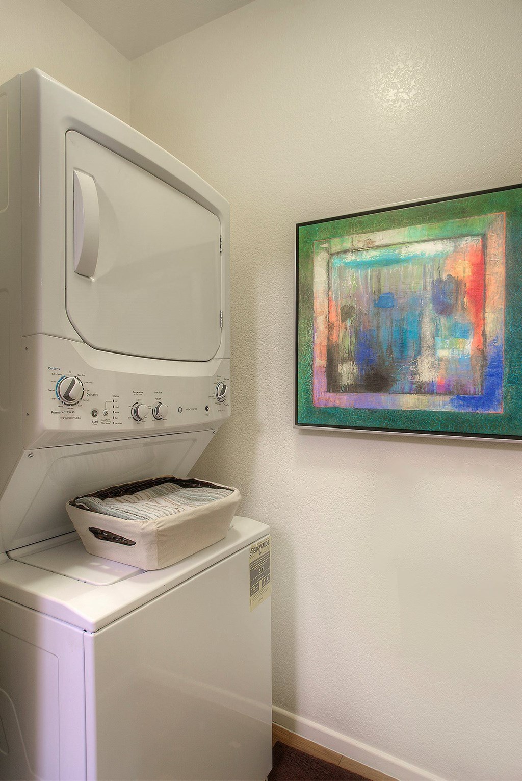 a washer and dryer in a laundry room with a painting